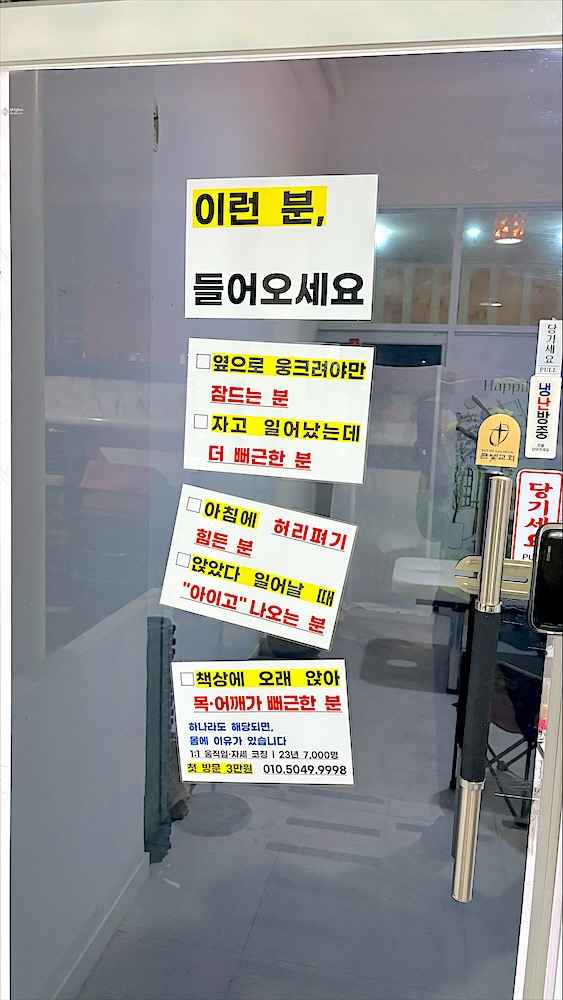 허리통증·목어깨 결림 등 이런 분 들어오세요 안내문이 붙은 출입문